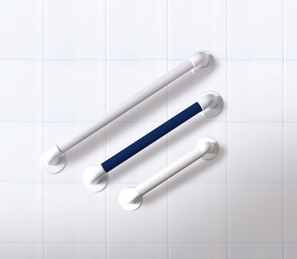 Large white fluted handle, medium dark blue fluted handle, and small white fluted handle, on a white bathroom wall. 