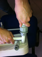 This image shows a pair of hands piecing together the product by attaching a leg to the seat frame. 