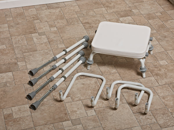 This image shows each part of the product deconstructed on a tiled brown floor. One seat with white cushion, 4 grey and white legs, a white metal back rest and two white metal arm rests. 