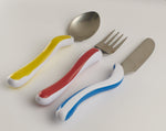 Image shows a yellow and white spoon, red and white fork and blue and white knife against a wooden background. 
