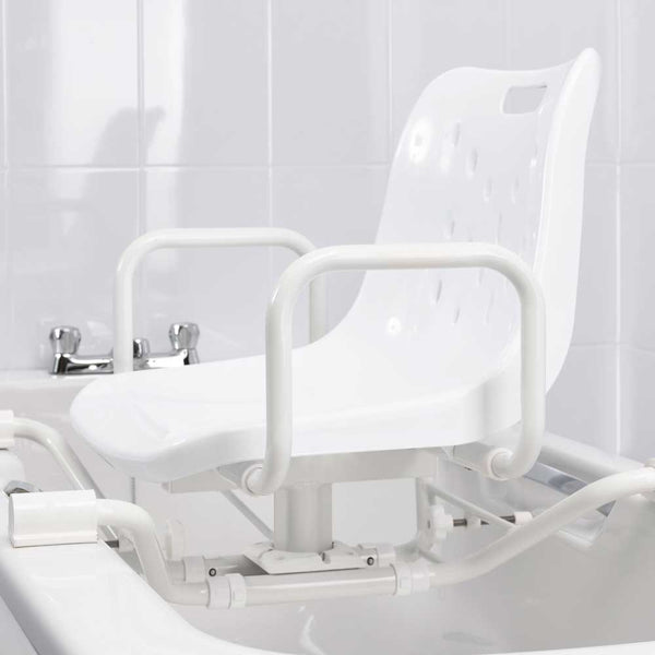 This image shows the white bath seat attached to a white bath in a white bathroom. This demonstrates how the white frame attaches across the width of the bath, and how the seat can swivel on the post that connects it to the frame.