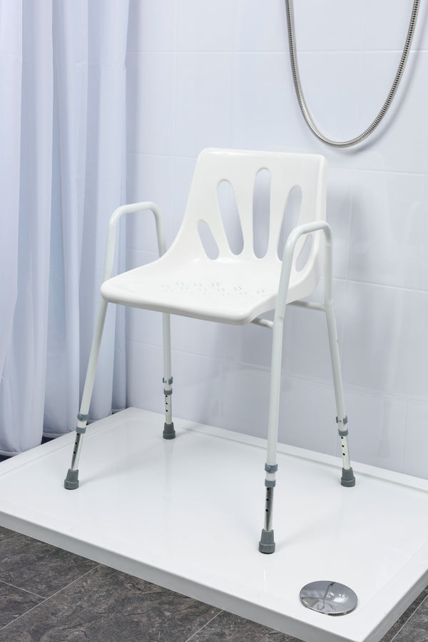 Image shows the white seat and framed shower chair set up in a white shower. 