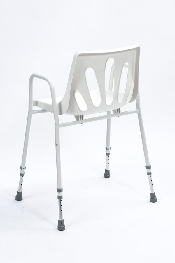 Image shows the white seat and framed shower chair from behind, against a white background. 