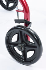 This image shows one of the black wheels of the red rollator model in close up, against a white background. 