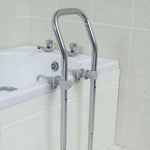 Image shows the chrome bath rail set up against a cream bath, demonstrating the clamps that fix the rail to the edge of the bath. 